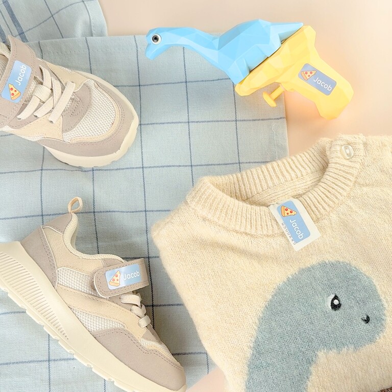 Namensaufkleber auf Pflegeetikett in Kinderkleidung
