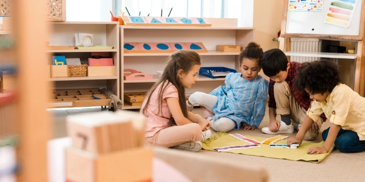Kinder spielen mit Montessori-Material auf dem Teppich