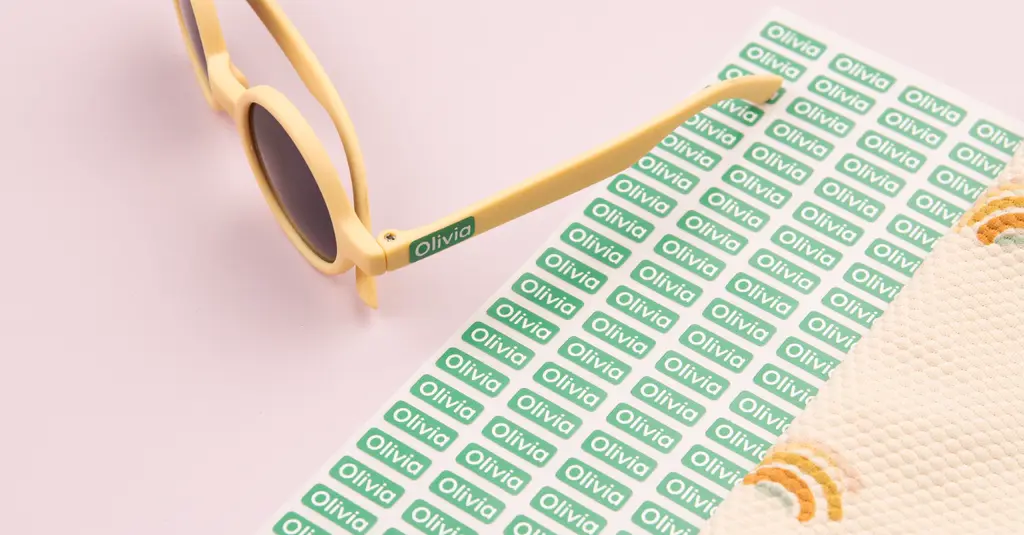 Grüne mini-aufkleber mit dem text "olivia" auf einer gelben sonnenbrille