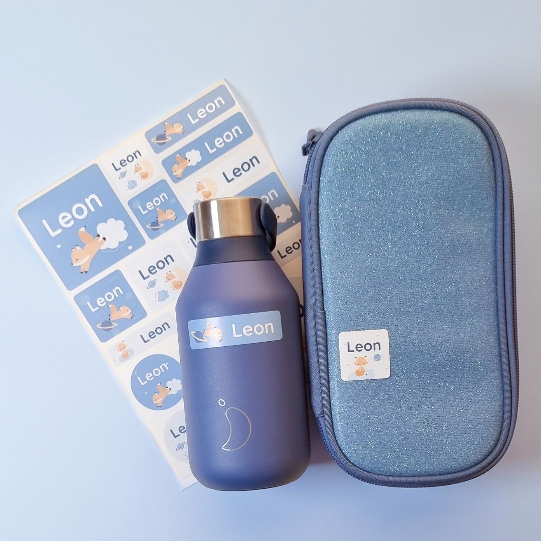 Blaue trinkflasche und federmäppchen mit personalisierten namensaufklebern mit fuchs und dem namen leon, daneben ein passendes stickerset