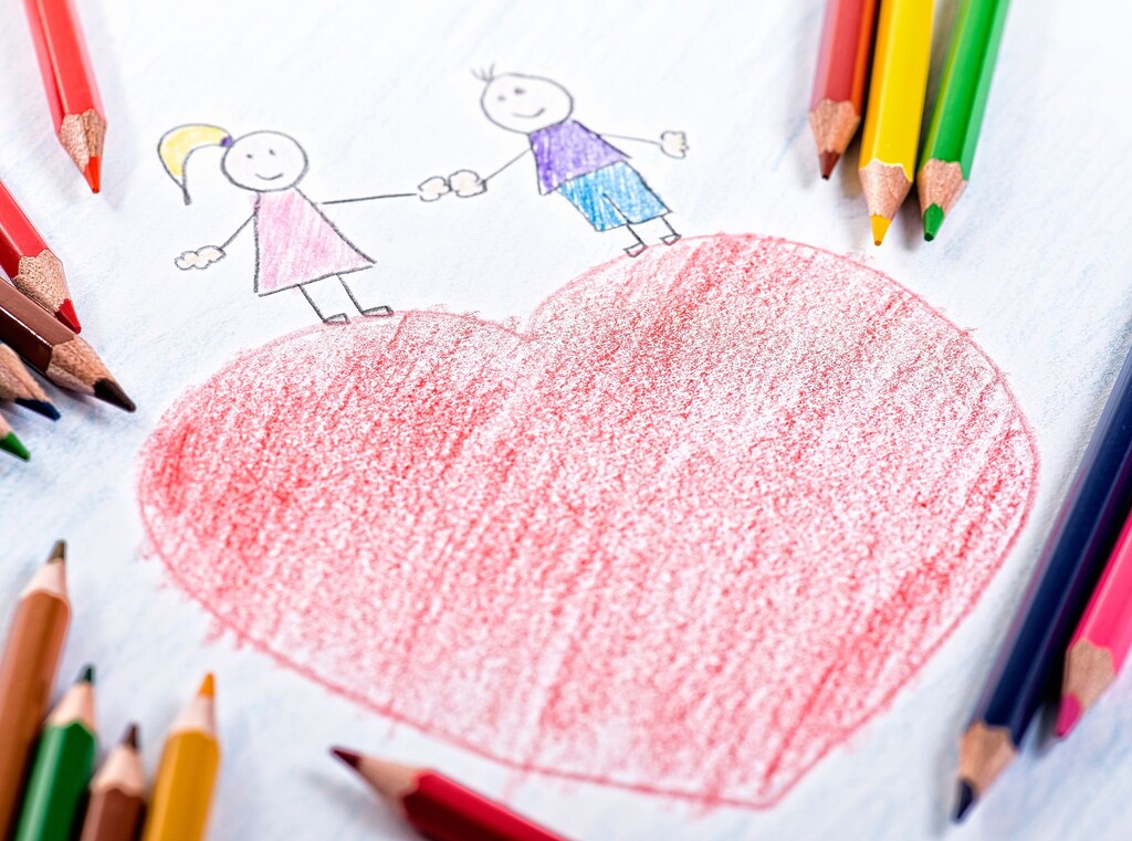 Valentinstag mit kindern: bastelideen und einfache rezepte, um liebe in der familie zu feiern 1 Selbstgemaltes, rotes herz mit zwei gezeichneten menschen umringt von buntstiften