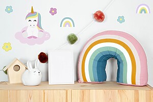 Kids' room with rainbow pillow and cute unicorn wall decals.