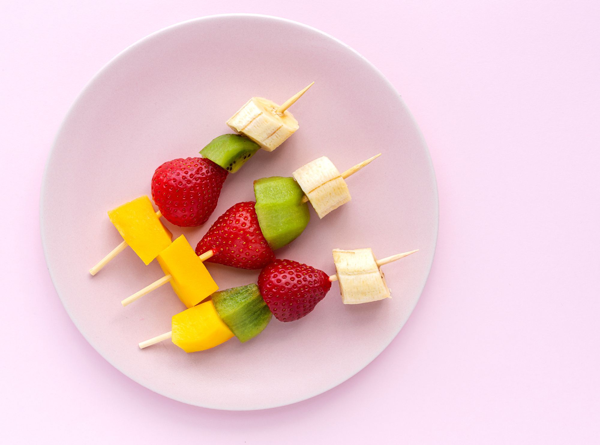 Obstspieße mit mango, erdbeeren, kiwis und bananen